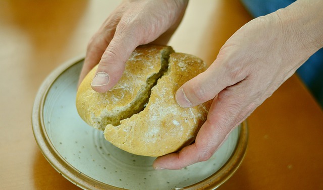 Brot wird beim jährlichen Nachbarschaftsessen auf dem Dorpsplein gebrochen